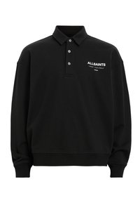 Musta pitkähiha polo-paita, joka on valmistettu puuvillasekoitteesta. Siinä on klassinen kaulus, kolme nappia ja valkoinen logopaino rinnan kohdalla.