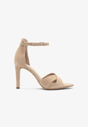 Beżowe zamszowe sandały na wysokim obcasie z otwartym palcem, krzyżowym wzorem z przodu oraz regulowanym paskiem na kostkę z srebrną klamrą.