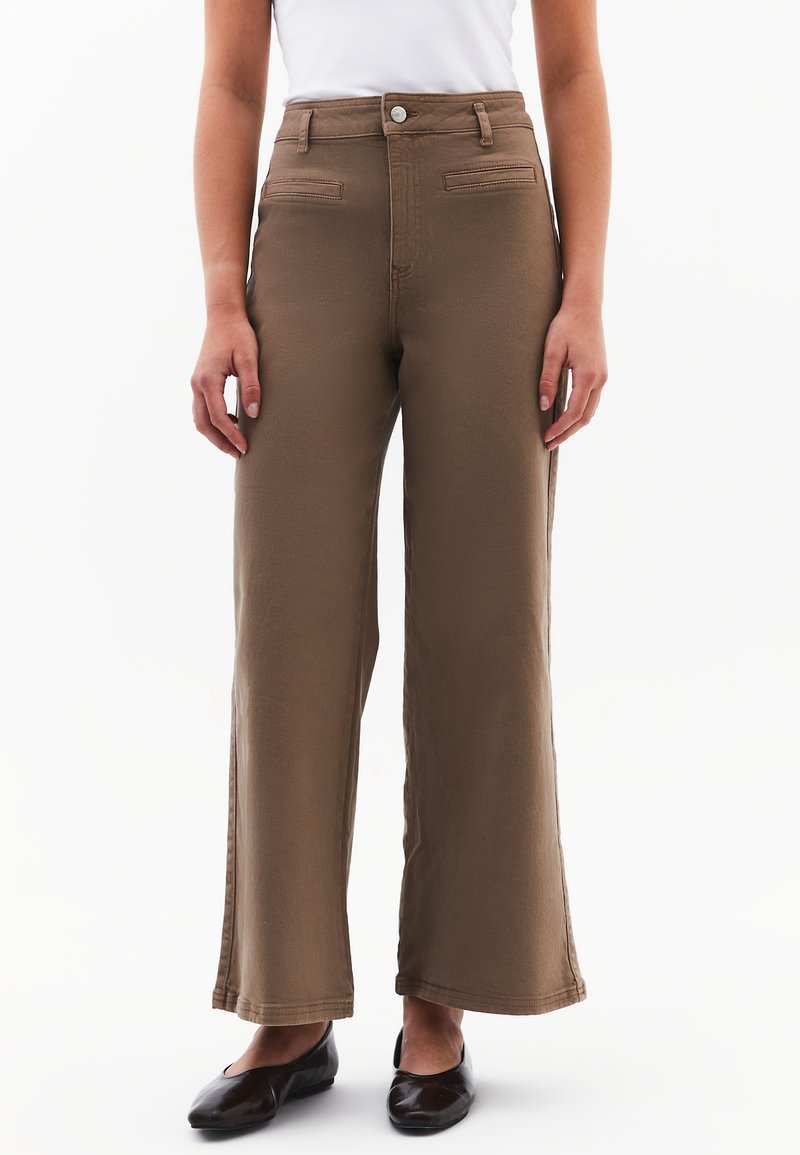 Ruske leve hlače z gladko teksturo, visokim pasom in dvema sprednjima žepoma; imajo gumb in zadrgo.