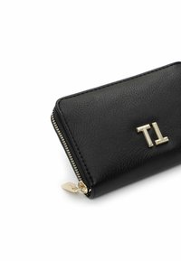Black textured leather zip-around wallet with silver zipper and metallic "TI" logo on the front.