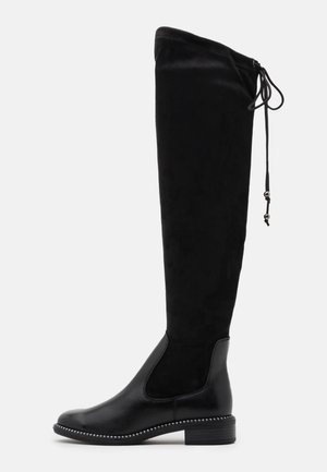 Czarny kozaki sięgające do kolan z zaokrąglonym noskiem, niskim obcasem typu słupek oraz regulowanym ściągaczem u góry zamszowego trzewika.