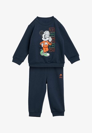Tamsiai mėlynas sportinis rinkinys, kuriame yra džemperis su Mikio Pelytės grafika ir derančios kelnės su oranžiniu "Adidas" logotipu ir akcentais.