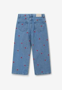 Jean en denim bleu avec une coupe décontractée, ornés de broderies en forme de cœurs rouges dispersées sur le tissu, deux poches arrière et une ceinture standard.