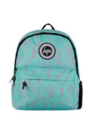 Turkoosi reppu, jossa on vaaleanpunaisia sydänkuvioita, mustia aksentteja ja pyöreä logo-patch. Varustettu päävetoketjulla ja etutaskulla.