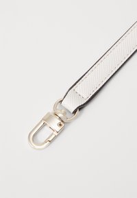 Cinturino tessuto bianco e nero con una chiusura in metallo argentato. Il cinturino presenta un motivo intrecciato e un bordo liscio.