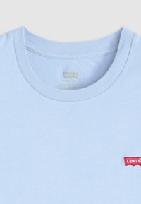Hele sinine puuvillane t-särkk, millel on ümmargune kaelus ja lühikesed varrukad. Vasakul rinnal on väike punane Levi'si logo. Pehme tekstuur.