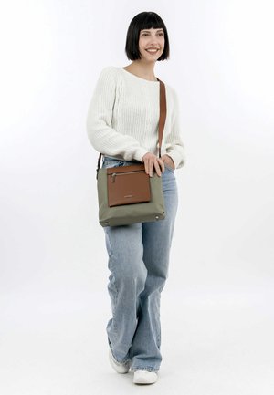 Green nylon crossbody bag with brown leather accent, featuring a zippered pocket, square shape, and metal hardware at the base.