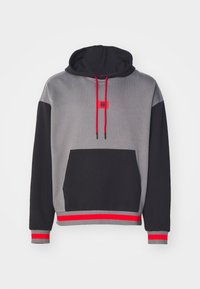 Sweatshirt à capuche avec un corps gris, des manches noires, des accents rouges et une poche frontale. Les cordons de serrage sont également rouges avec des embouts noirs.