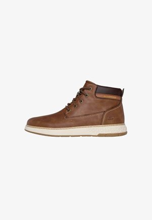 Botas de tobillo impermeables marrones con parte superior de cuero texturizado, punta redonda y suela de goma blanca en contraste. Incluye ojales metálicos y cordones.