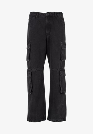 Mustad denim kaubanduspüksid, laia lõikega, mitmete külgtaskutega ja õmblustega detailses. Materjali tekstuur on veidi kulunud.