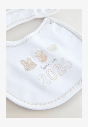 Valkoinen puuvillabib, jossa on vaaleat brodeeraukset pupusta, tassunjäljestä ja karhusta, sekä teksti "syntynyt vuonna 2026" pehmeissä pastelliväreissä ja ommelluilla yksityiskohdilla.