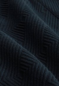 Dark navy fabric with a textured herringbone pattern. The material appears soft and slightly fuzzy, showcasing ridged lines throughout.