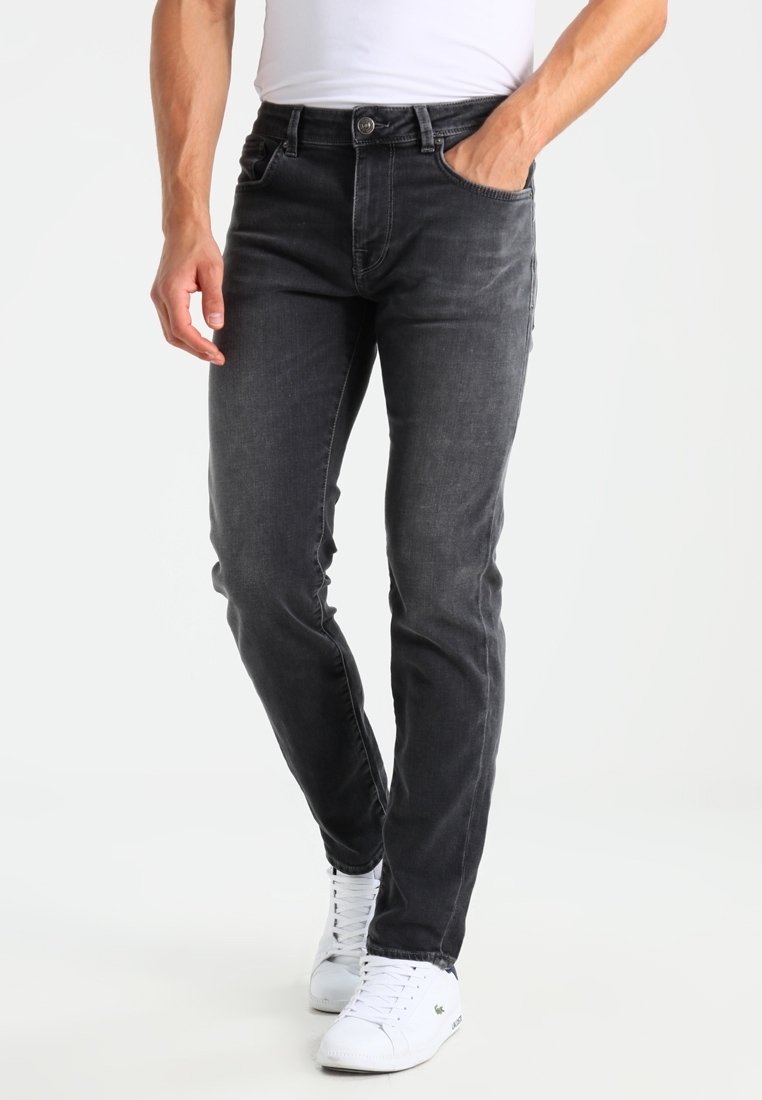 Slim-fit grå denimjeans med en blekt finish, femficksdesign och metallknappstängning. Stylad med vita sneakers.