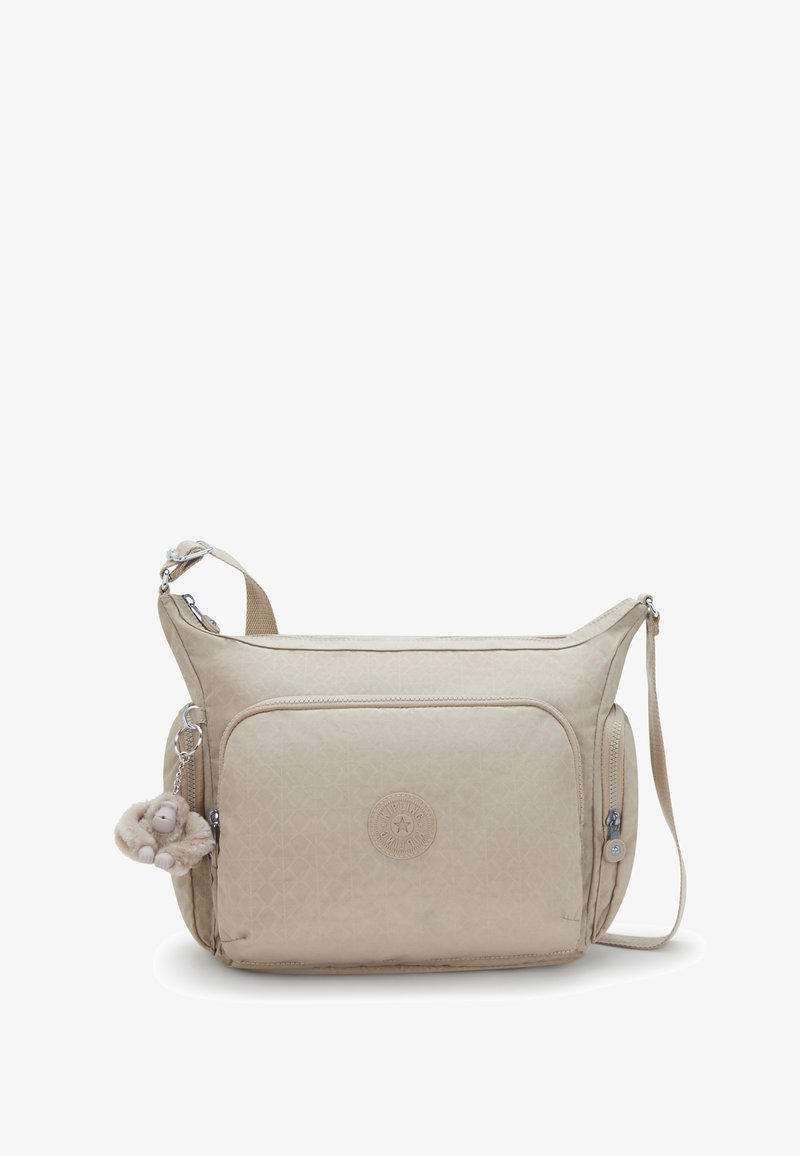 Beige Umhängetasche mit strukturiertem Muster, ausgestattet mit einem Reißverschluss-Hauptfach, einer Vordertasche und einem flauschigen Affenanhänger.