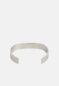 Bracelet manchette en métal avec une surface lisse et polie et des accents à motifs carrés aux extrémités. Couleur : argent. Design simple et élégant.