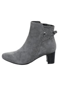 Harmaa mokkanahkainen nilkkuri, jossa on terävä kärki, koristeelliset hopeanväriset niitit sivuilla ja takana oleva nauha, jossa on pyöreä metallinen koriste. Matala korko.