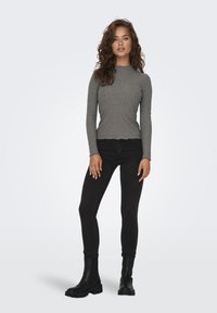 Gray ribbed long-sleeve top with scalloped hem, paired with black skinny jeans and black chunky ankle boots.