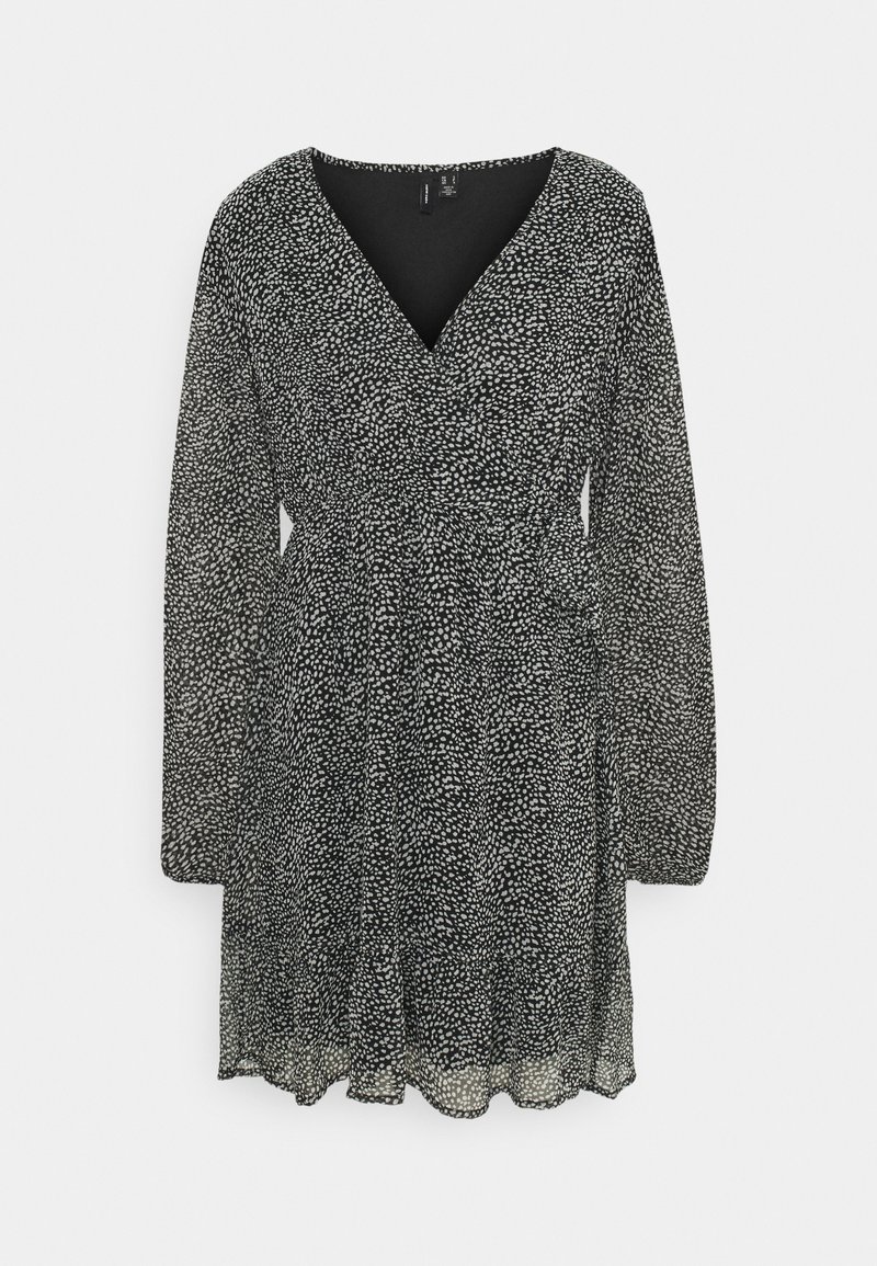 Robe noire avec un design enveloppant, décolleté en V, manches longues et jupe plissée. Le tissu présente un motif blanc à pois sur l'ensemble.