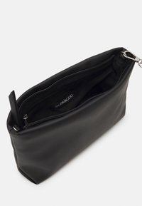 Černá syntetická kožená taška obdélníkového tvaru se zipovým uzávěrem nahoře a vnitřním podšívkou. Obsahuje malou logo etiketu uvnitř.
