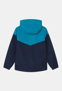 Hooded regnjacka med en färgblockdesign i turkos och marinblå. Slät textur med elastiska manschetter och en avslappnad passform.