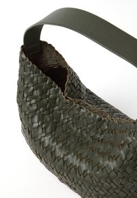 Bolso de cuero verde trenzado con un acabado texturizado, que cuenta con una correa plana a juego. La forma es curva y semiestructurada.