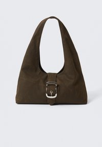 Bolsa de lona marrón con forma de hobo, asa ancha y un acento de hebilla plateada en la parte delantera. Textura suave con un ligero brillo.