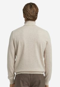 Beżowy sweter z wysokim kołnierzem, prążkowymi mankietami i prostym krojem, wykonany z miękkiego, strukturalnego materiału. Widok z tyłu pokazuje minimalne detale.