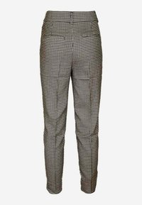 Pantaloni su misura in un motivo houndstooth bianco e nero, caratterizzati da una vestibilità dritta, tasche e una texture del tessuto liscia.