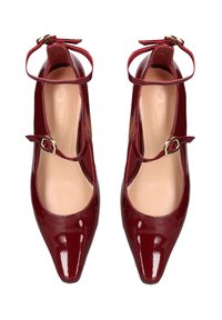 Scarpe con tacco Mary Jane in pelle verniciata rossa, con punta appuntita, cinturino alla caviglia e dettagli in oro. Finitura liscia e fodera interna neutra.
