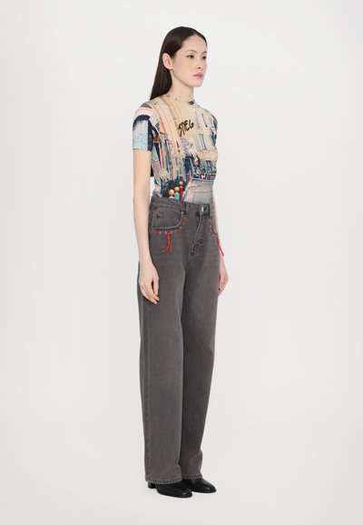 Graphic t-shirt featuring a colorful street scene, paired with high-waisted, loose-fitting dark gray jeans with red drawstring details.