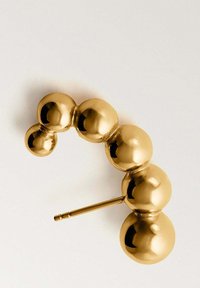 Pendiente de aro dorado compuesto por esferas brillantes conectadas de diferentes tamaños con un poste recto para el piercing.