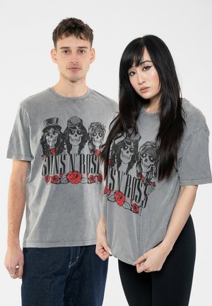 Gray cotton t-shirts feature a graphic design with skulls, roses, and "Guns N' Roses" text. Casual fit, round neck, short sleeves.