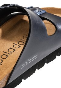 Marinblå lädersandal med en korkfotbädd, med rem och spänne. Texturerad sula med ränder för grepp. Logotyp tryckt på fotbädden.
