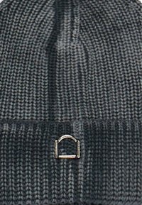 Gorro de punto en color carbón con un patrón texturizado y un pequeño detalle metálico plateado en la parte delantera. Diseño ajustado para brindar calor.