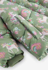 Manche de veste matelassée verte avec des motifs de licorne, arc-en-ciel, papillon, fleur et souris, comprenant un poignet et un rabat de poche.