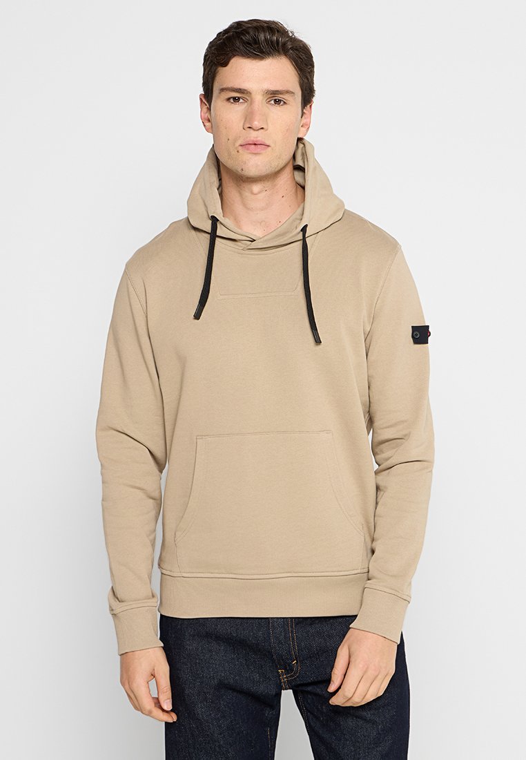 Beige hoodie met een voorzak, verstelbare trekkoorden en zwarte accenten. Zacht materiaal, ribbelmanchetten en -zoom.