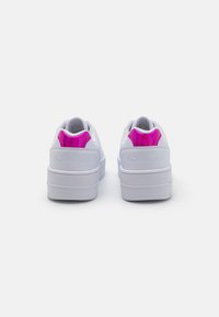 Sneakers bianchi con una parte superiore liscia, colletto imbottito e un accento sul tallone rosa lucido. Suola in gomma spessa con battistrada testurizzato per una migliore aderenza.