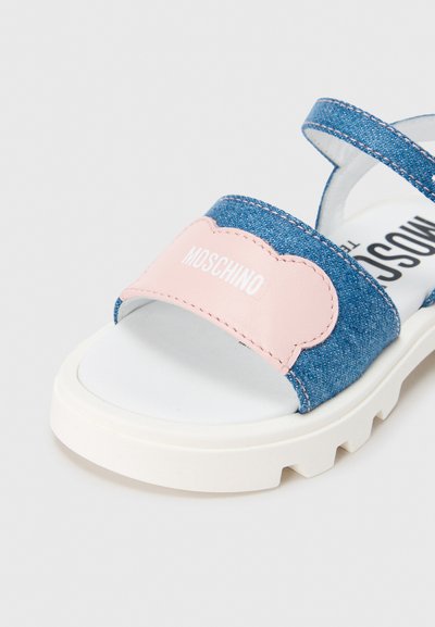 Πέδιλο από τζιν με ανοιχτό ροζ λουράκι με λογότυπο, λευκή σόλα και υφή. Ρυθμιζόμενο λουράκι για σταθερή εφαρμογή. Καθημερινό σχέδιο.