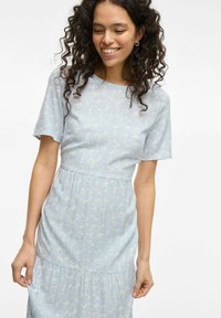 Robe bleu clair à manches courtes, dotée d'un motif floral, d'un buste cintré et d'une jupe à volants. Tissu doux avec une texture lisse.