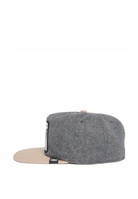 Gray wool cap with a tan visor, featuring a flat brim and a small tag on the side. The fabric has a textured appearance.