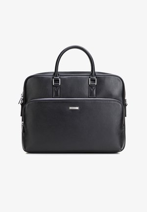 Mallette en cuir noir avec deux poignées, poche avant zippée et plaque de marque argentée centrée sur la poche.