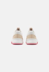Zapatillas deportivas con parte superior de malla blanca, talón y entresuela sintéticos beige, y suela exterior de goma rosa. Incluyen una lengüeta para tirar en el talón.