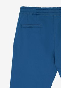 Modré kalhoty vyrobené z hladké látky, s elastickým pasem a zadní kapsou s jemným švem.