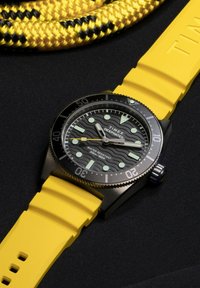 Reloj de pulsera Timex Deepwater con esfera negra, correa de silicona amarilla, marcadores luminiscentes y caja de acero inoxidable negro. Resistente al agua hasta 200m.