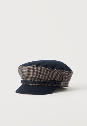 Καπέλο τύπου flat cap σε σκούρο μπλε και καφέ μοτίβο houndstooth με μικρό γείσο και διακοσμητικό σκοινί σε ναυτικό μπλε πάνω από το γείσο.