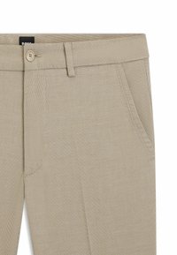 Beige elastische broek met een gladde textuur, knoopsluiting, riemlussen en twee zijzakken. Casual, aansluitend ontwerp.