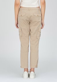 Beige cargobyxor med två sidofickor, bakfickor och knappar som accent; kort längd; tillverkade av ett mjukt, slitstarkt material.