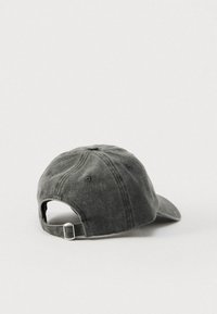 Temno siva bombažna bejzbol kapa z zbledelo teksturo, ukrivljenim robom in nastavljivo kovinsko zaponko na zadnji strani. Vidnih je šest prezračevalnih lukenj.