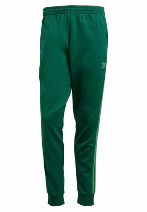 Pantaloni sportivi verdi realizzati in tessuto morbido; presentano un elastico in vita, polsini a coste e strisce laterali a contrasto con un piccolo logo.