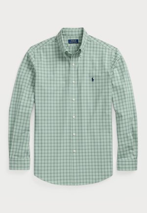 Camisa de vestido xadrez verde-claro com colarinho abotoado, mangas longas e um detalhe em logotipo azul-marinho no peito. Material de algodão.